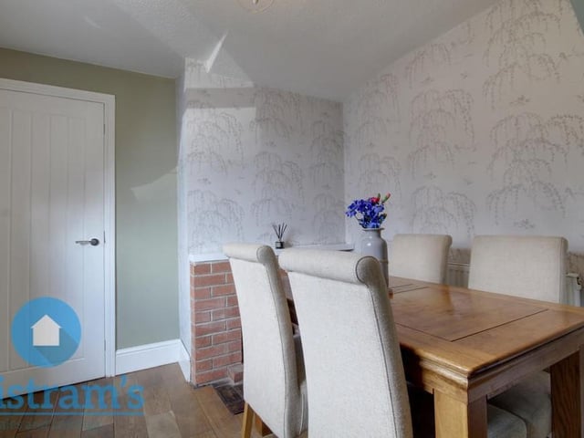 Here is the cottage's dining room, which is accessed via the living room and also leads directly to the kitchen. It has a fitted fireplace, wood flooring and a uPVC window to the front of the home.