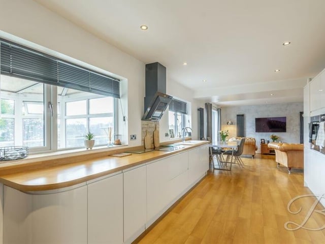 The living room/diner, which you can spot in the background, flows seamlessly into a wonderful kitchen, which features a range of integrated appliances, including a double oven, microwave, warming drawer and dishwasher. It is fitted with gloss wall and base units, a work surface, a ceramic hob and inset sink with mixer tap. Downlights and laminated flooring add to its appeal.