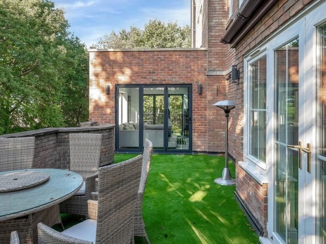 The lounge opens out on to this stunning balcony, which is a large, outdoor entertaining space with brick wall, stone pillars and a charming backdrop of mature trees. There is also an artificial Astroturf floor, four light points and access to the kitchen via bi-fold doors.