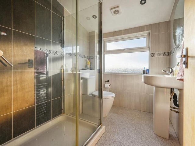 Sitting between the two bedrooms on the second floor is this newly-fitted shower room, with a walk-in shower that runs off the mains, a ceramic toilet, ceramic wash hand basin, spotlights, wall-mounted towel-radiator, tiled splashbacks and vinyl floor.