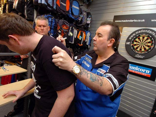 Phil The Power Taylor signs the top top of darts fan David Grove, of Sprotbrough, during his autograph session at InterSport, Doncaster in 2009