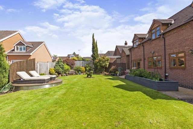 Our last two photos focus on the stunning back garden. It is wonderfully presented, complete with a pristine lawn, mature shrubs and bushes, flowerbed edging and a raised decked area, which is perfect for sunbathing in the summer.