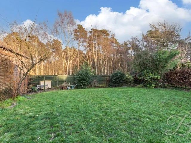 To the rear, a well-maintained lawn extends into a private garden, the perfect place to relax and unwind.
