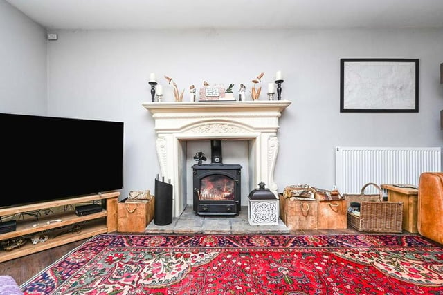 The entrance hall leads into this lovely lounge, which is dominated by a feature fireplace with multi-fuel log-burner. It also boasts Karndean flooring and a uPVC double-glazed widow to the front of the property.