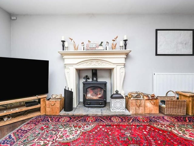 The entrance hall leads into this lovely lounge, which is dominated by a feature fireplace with multi-fuel log-burner. It also boasts Karndean flooring and a uPVC double-glazed widow to the front of the property.