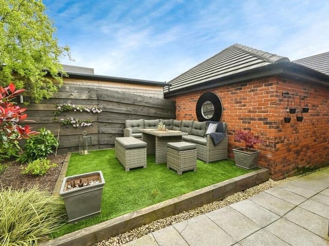 The rear garden is a delight, complete with three areas for seating, including this cute corner with a raised lawn.