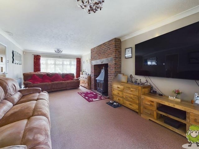 The first reception room to look at is this large living room or lounge, which boasts a feature fireplace and multi-fuel log-burner.