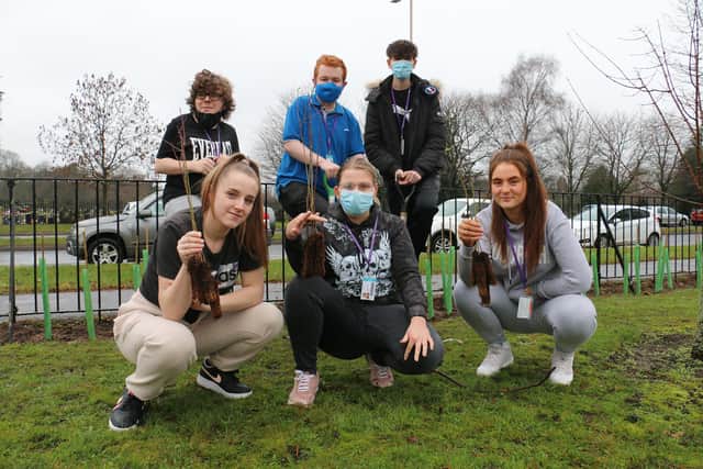 Level one business studies students with the tiny saplings ready to plant.