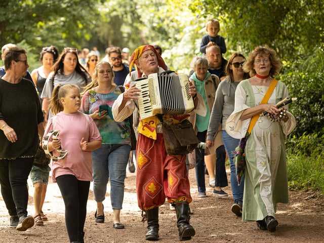 Entertainer Bill Brookman leads the parade to the Major Oak, July 30.