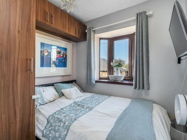Another bedroom that faces the front of the £250,000 cottage via a double-glazed bay window. It also boasts built-in cupboards and a TV point.