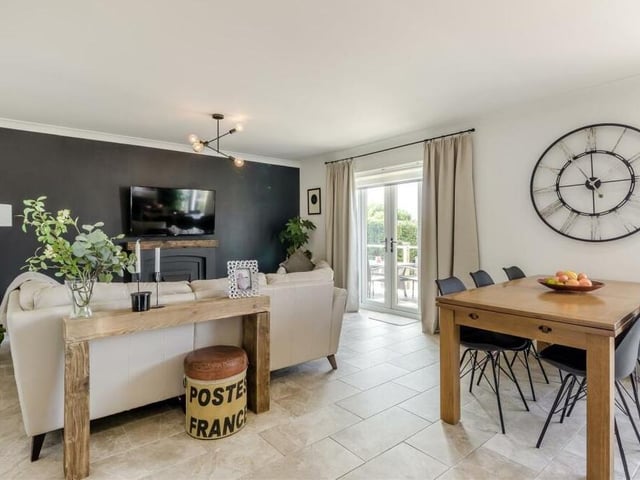 Let's move seamlessly now into the lovely living area that is part of the open-plan hub at The Gables bungalow. As you can see, there are French doors leading outside.