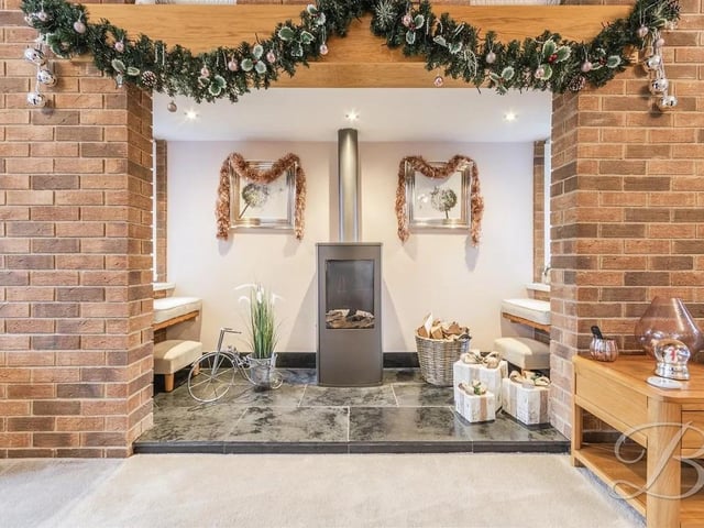 The stylish living room features a stunning brick feature wall which sets bock the gas fireplace, with windows either side.