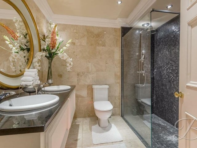 As well as a family bathroom, the Mansfield property features two shower rooms, including this stylish one on the first floor. It comprises a walk-in shower cubicle with waterfall shower, double hand wash basin, low-flush WC, full-height tiling and downlights.