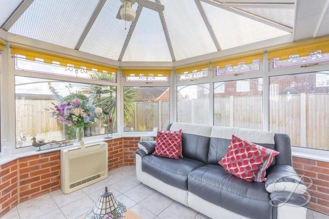 A second shot of the classy conservatory. It includes a central heating radiator, while all the windows overlook the back garden.
