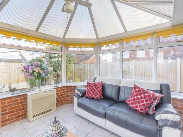 A second shot of the classy conservatory. It includes a central heating radiator, while all the windows overlook the back garden.