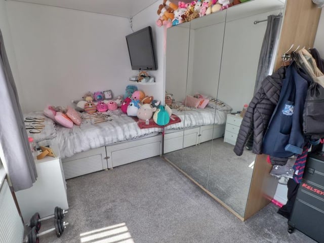 There's lots going on in this busy bedroom. But it has the space for it. Again, the floor is carpeted.