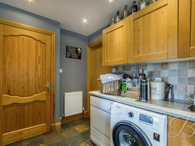 Just off the kitchen is this useful and separate utility room, where there are more units, another sink and space for a washing machine and tumble dryer.