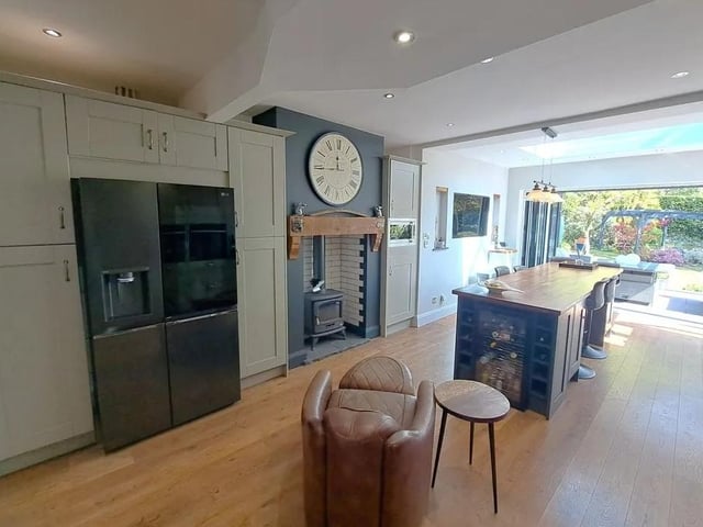 The bi-fold doors and statement skylight flood the kitchen/dining/living space with natural light.