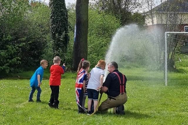 Youngsters have fun with a fire hose.