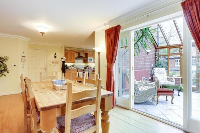 The open-plan layout of the kitchen allows it to merge with this second dining area, which has laminate flooring and coving to the ceiling. Double doors lead into the conservatory.