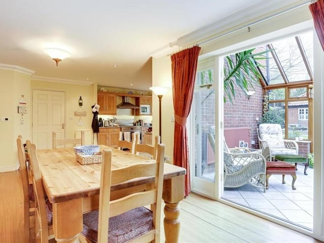 The open-plan layout of the kitchen allows it to merge with this second dining area, which has laminate flooring and coving to the ceiling. Double doors lead into the conservatory.