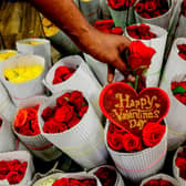 A florist arranges roses flowers at a shop ahead of Valentine's Day. (Photo by ARUN SANKAR/AFP via Getty Images)