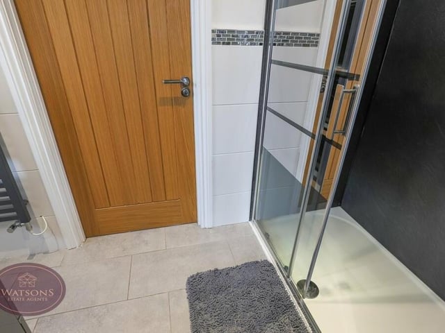 The second en suite shower room on the first floor serves the second and third bedrooms. It includes a shower cubicle with mains-fed shower, vanity sink unit, WC, chrome. heated towel-rail, ceiling spotlights, fully tiled walls, a porcelain tiled floor and underfloor heating.