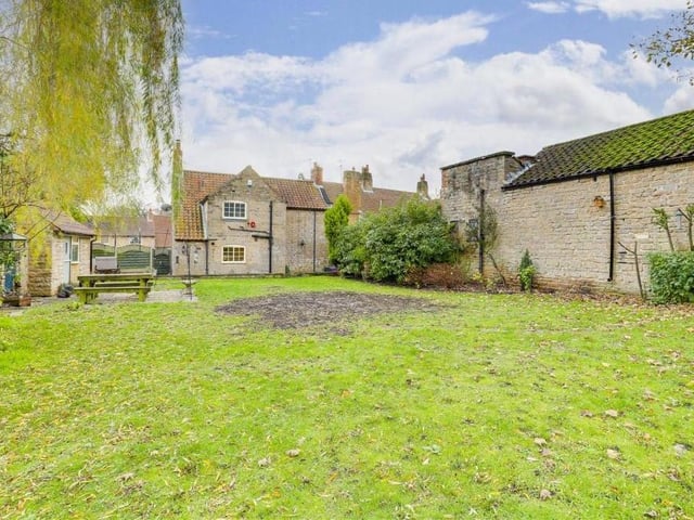 The private and enclosed back garden boasts a large lawn, a range of plants and shrubs and also a paved patio area.