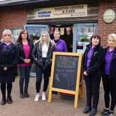 Staff with 'Save Rumbles' sign at Rumbles Community Cafe.