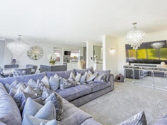 The open-plan living area oozes luxury. A carpeted floor and stylish wall-lights add to the feeling of warmth.