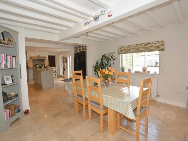 Next to the kitchen is this quaint dining area. A Yorkshire casement window lets in lots of light, while the floor is tiled and the ceiling beamed.