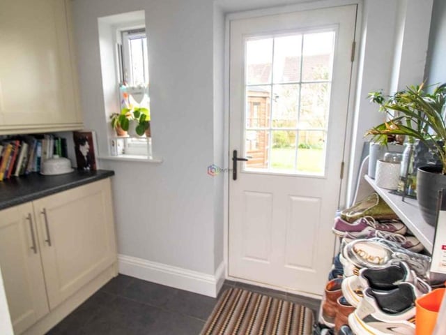 A handy utility room at the Willowbridge Lane house contains more kitchen units and work surfaces. A door leads to the back of the property, and there is also access to a downstairs toilet, which is fitted with a white wash hand basin and WC.