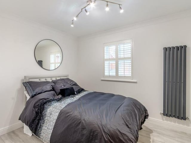 Another comfortable bedroom, this one overlooking the front of the £500,000 property. It features wardrobes, a laminate floor and a contemporary, vertical aluminium radiator.