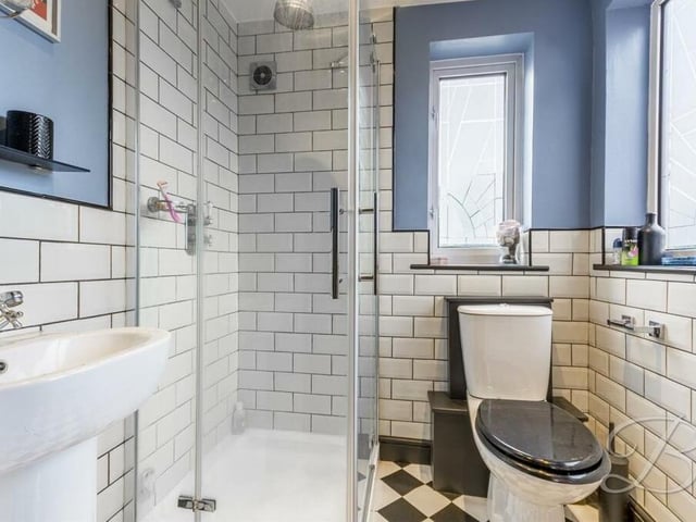The full-height tiling gives this en suite shower room to the master bedroom an attractive vintage look. It comes complete with an enclosed shower, pedestal sink, low-flush WC and extractor fan.