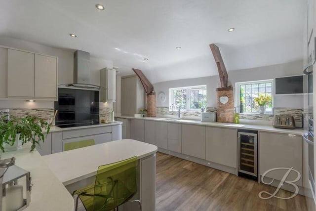 The stunning and spacious kitchen comes with a range of modern gloss units and cabinets, with complementary work surfaces and an inset double sink. A built-in breakfast bar is a nice touch, and a handy utility room, with integrated washing machine, is not far away.