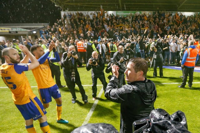 Manager and players celebrate with the army of away fans at the end.