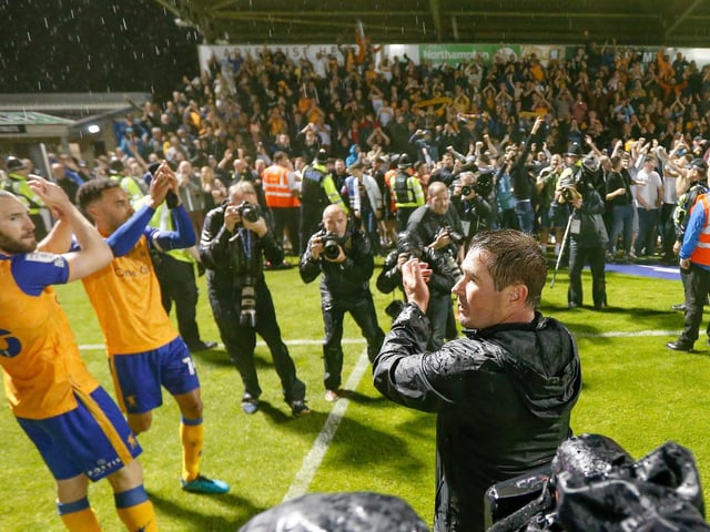 Manager and players celebrate with the army of away fans at the end.