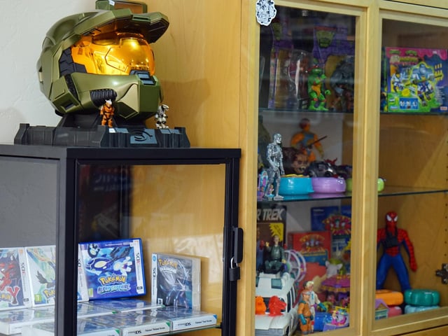 The shop features a cabinet filled with retro toys, showcasing numerous pop culture figurines.