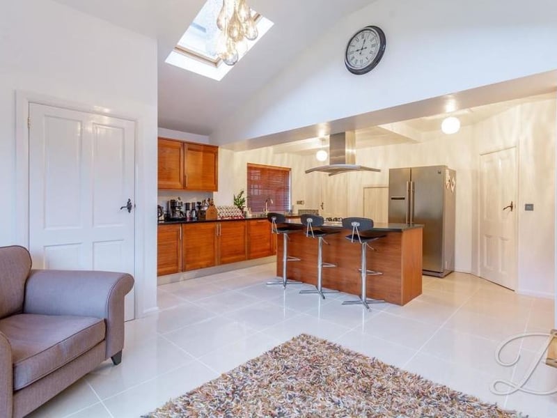 The kitchen also includes a living space with room for sofas or chairs.