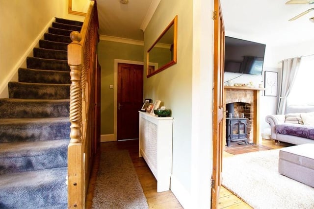 The entrance hallway provides a warm welcome to the three-floor property. It has wood flooring, stairs leading to the first floor and an under-stairs cupboard for storage.