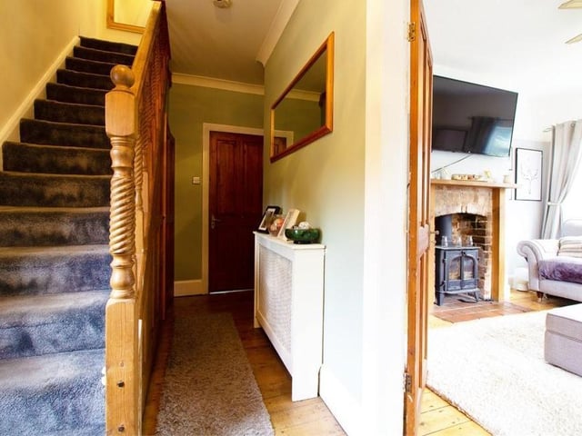 The entrance hallway provides a warm welcome to the three-floor property. It has wood flooring, stairs leading to the first floor and an under-stairs cupboard for storage.