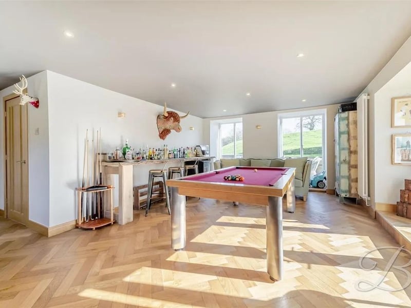 A spacious and highly versatile games room, currently utilised as a stylish bar and pool room, offering an ideal space for entertaining with family and friends.