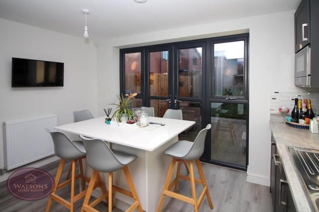 The kitchen also features a central island, offering further storage space and room for chairs, as well as French doors leading to the back garden. Ceiling spotlights and luxury vinyl tiled flooring add to the appeal of the room.