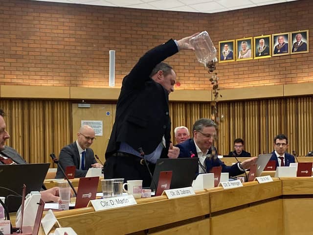 Coun Dave Hennigan emptied a jar of coins on to the chamber floor during his speech