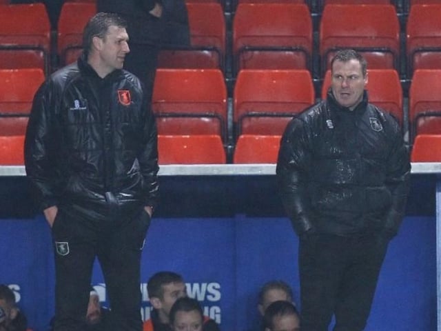 Mansfield boss David Flitcroft (right) looks on in the rain.