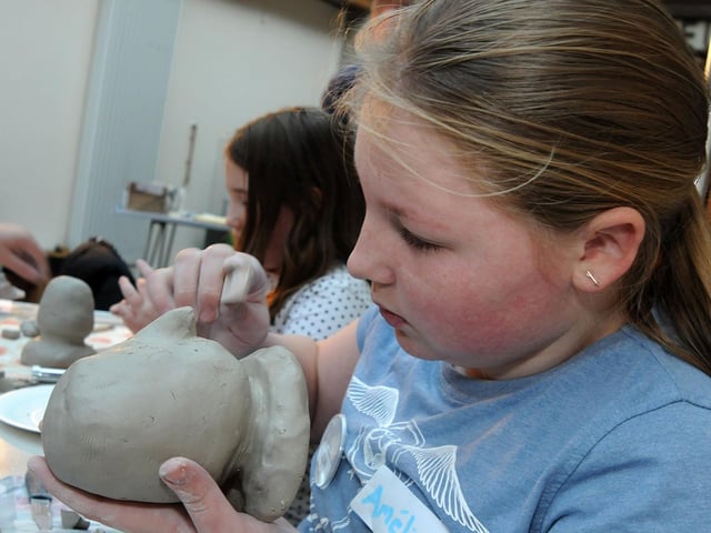 Mud heads challenge Mansfield Museum.     Amelie Loates, 12, works on the facial features of her mud head replica in 2017.