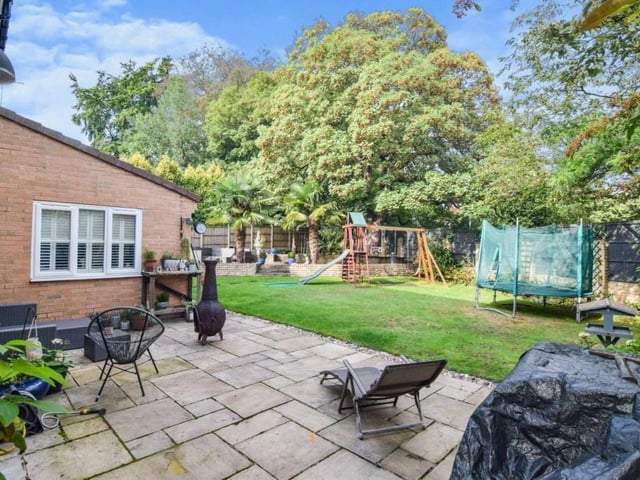 Moving back outside now, this is an area of the enclosed, landscaped garden at the back of the property. It features established trees and bushes.