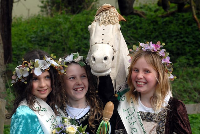 May Queen Chloe Hodgson, centre, pictured with her attendants Harriet Rhodes, left, and Olivia Bradley as the Morris Men's horse joins in the picture at the  Edwinstowe May Day Festival.