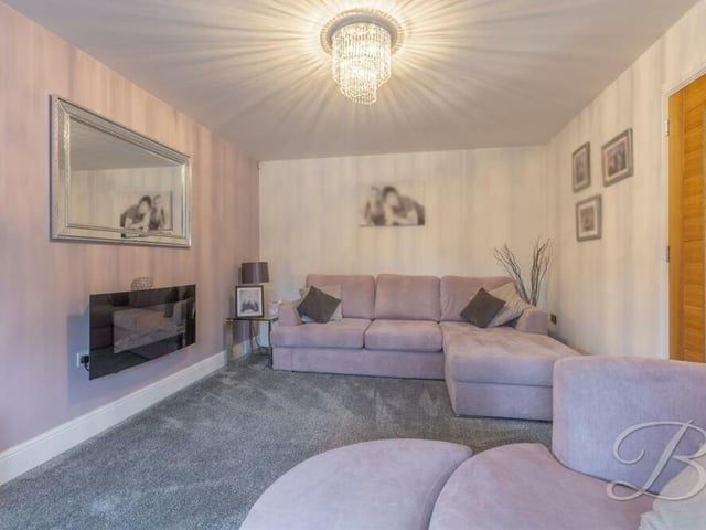 This cosy lounge or living room offers a pleasant second reception room on the ground floor. It boasts fitted carpets, an electric fireplace and a bay window facing the front of the property.