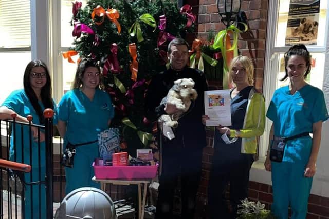 Staff outside the Thompson Vets with the Christmas tree and food donation point